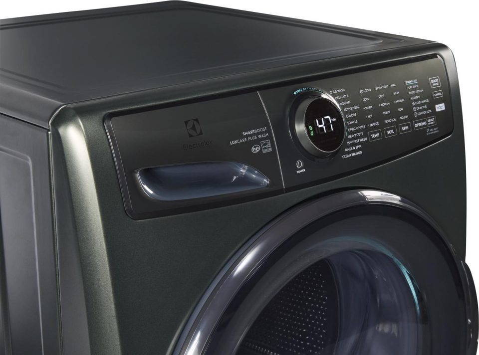 Close-up of a dark green Electrolux washing machine featuring a large digital display showing "47" and an extensive control panel with various buttons and settings for different washing cycles. The door has a sleek chrome edge.