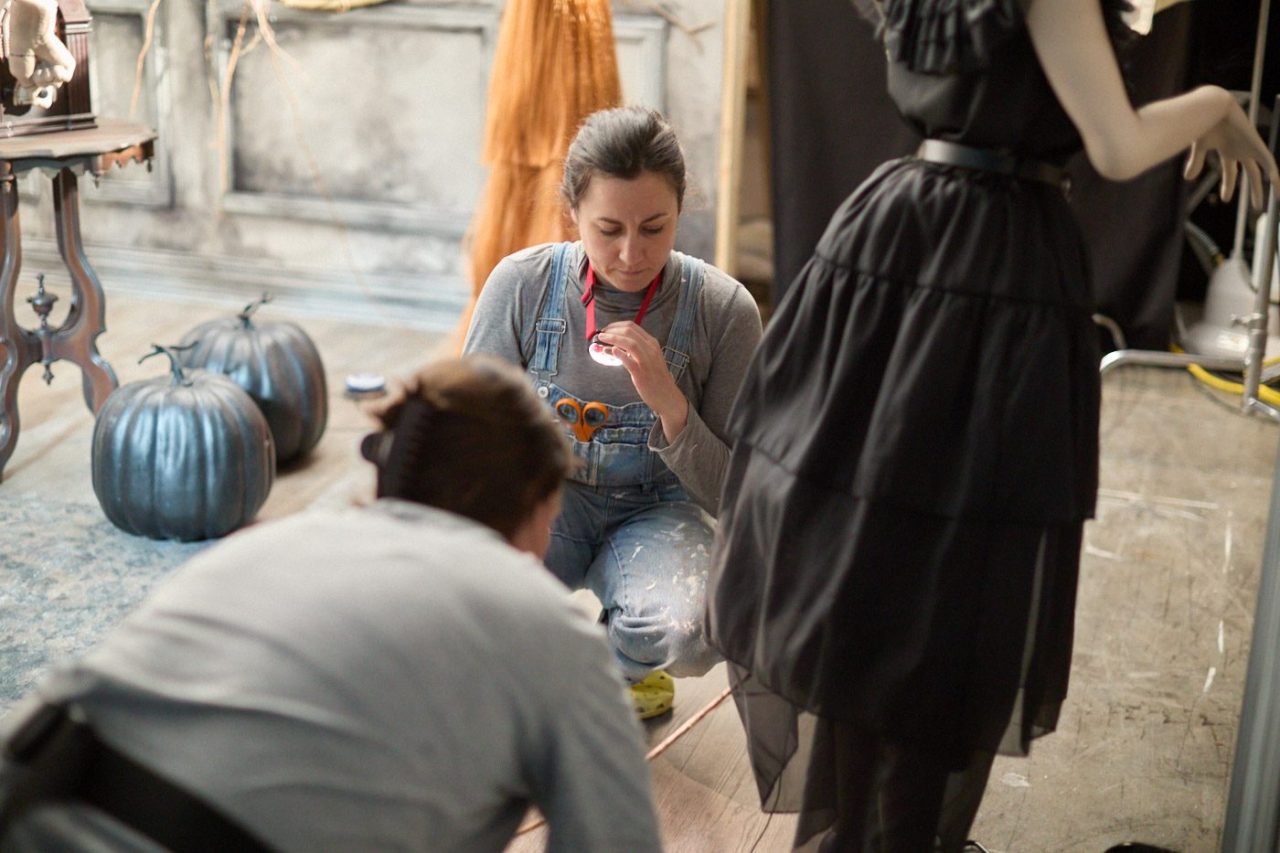 Product stylists arranging a Halloween-themed store photoshoot.