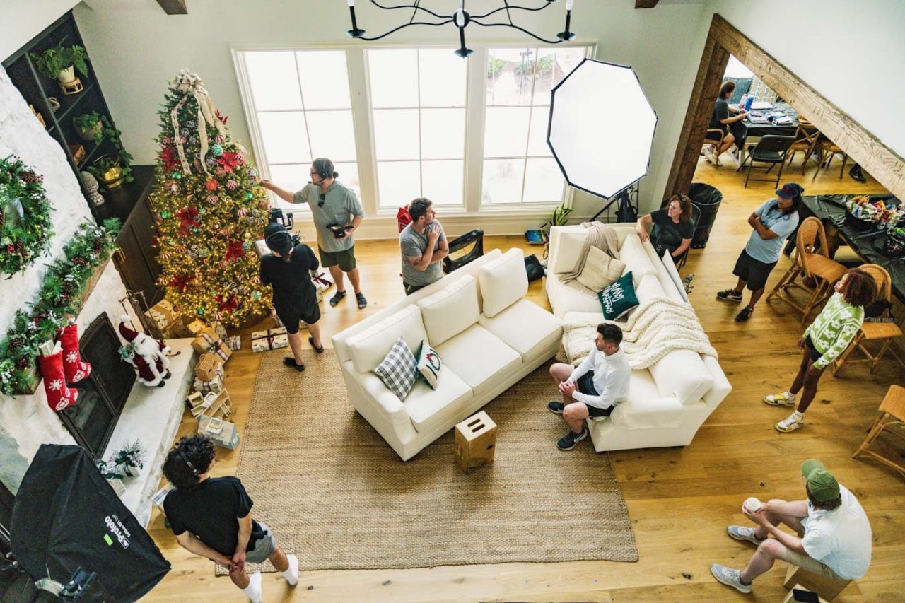 Set of a holiday living room filled with members of a creative production team.