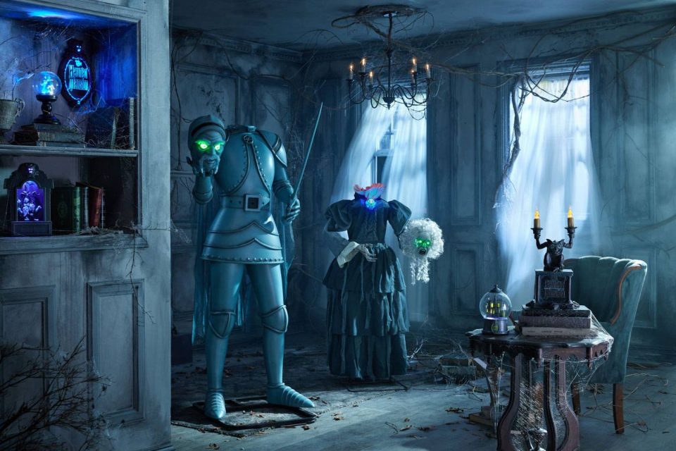 A dimly lit haunted room with blue-tinted armor holding a lantern, a spooky mannequin in a dress, and ghostly figures. Cobwebs drape old furniture; eerie blue and green lights glow from various objects, creating a mysterious atmosphere.