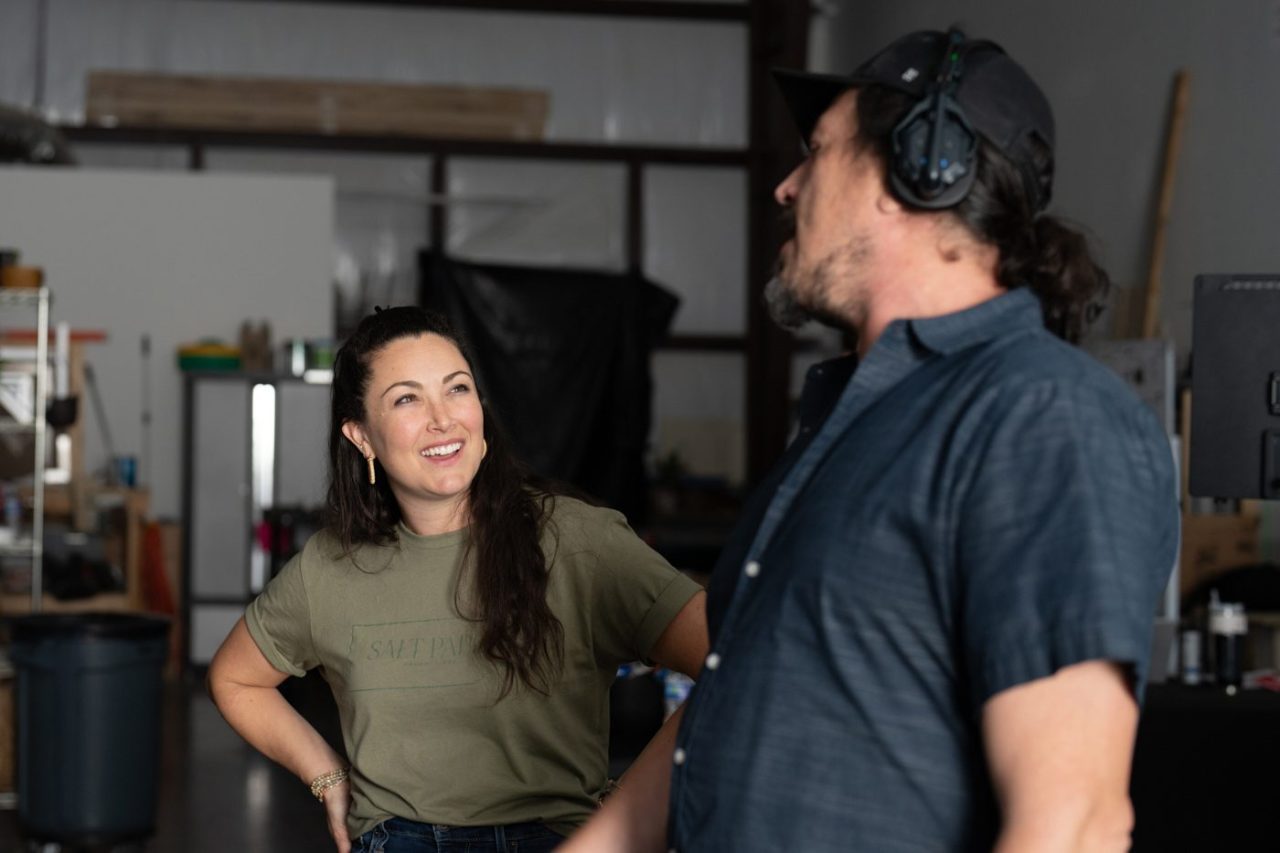 Photograph of creative team members laughing and working behind the scenes in a studio.