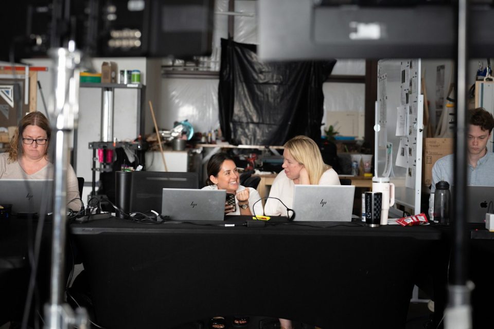 Two creative producers discussing a project on the laptops in the studio.