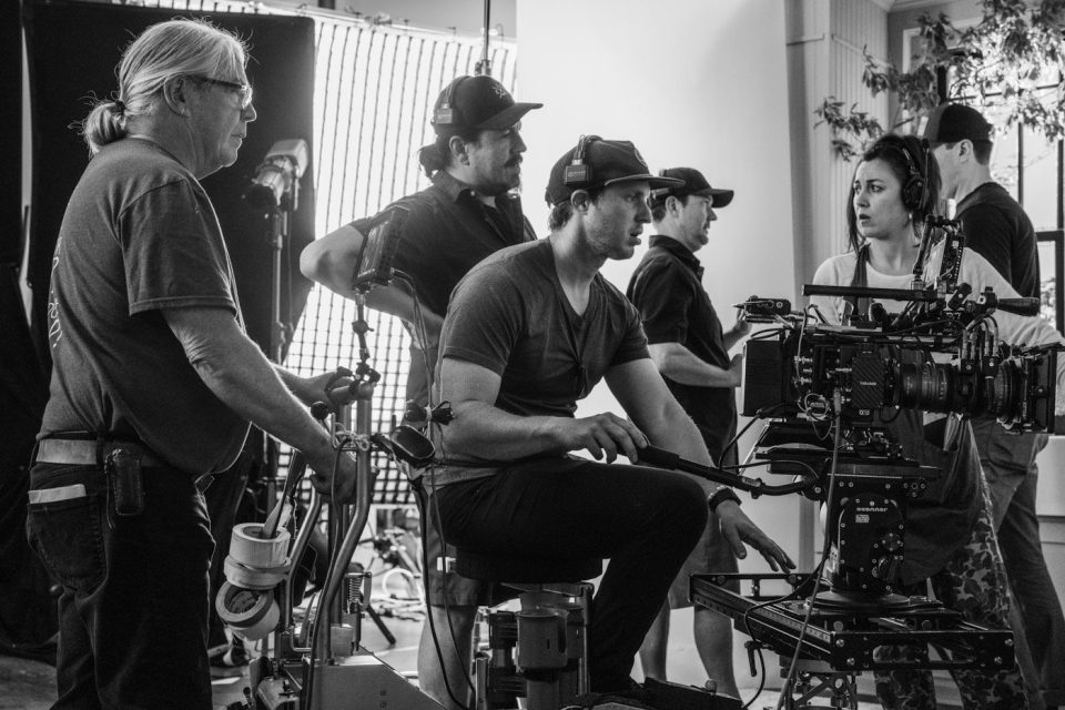 Black and white photo of a creative studio team collaborating around a large camera.