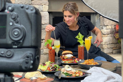 Image of a photo stylist arranging food in front of the camera.  