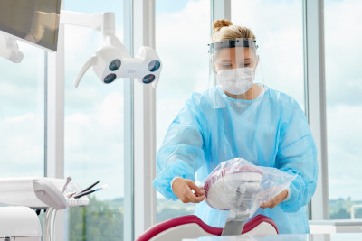 Photograph of dental assistant prepping a dental exam chair.