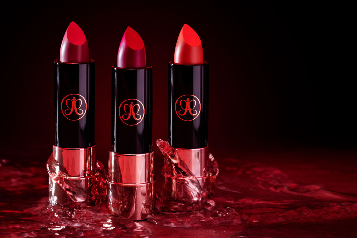 Striking lifestyle product photo of luxury red lipstick tubes against a black backdrop