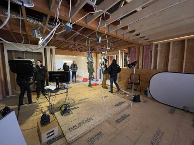 Interior construction site with photography crew setting up.